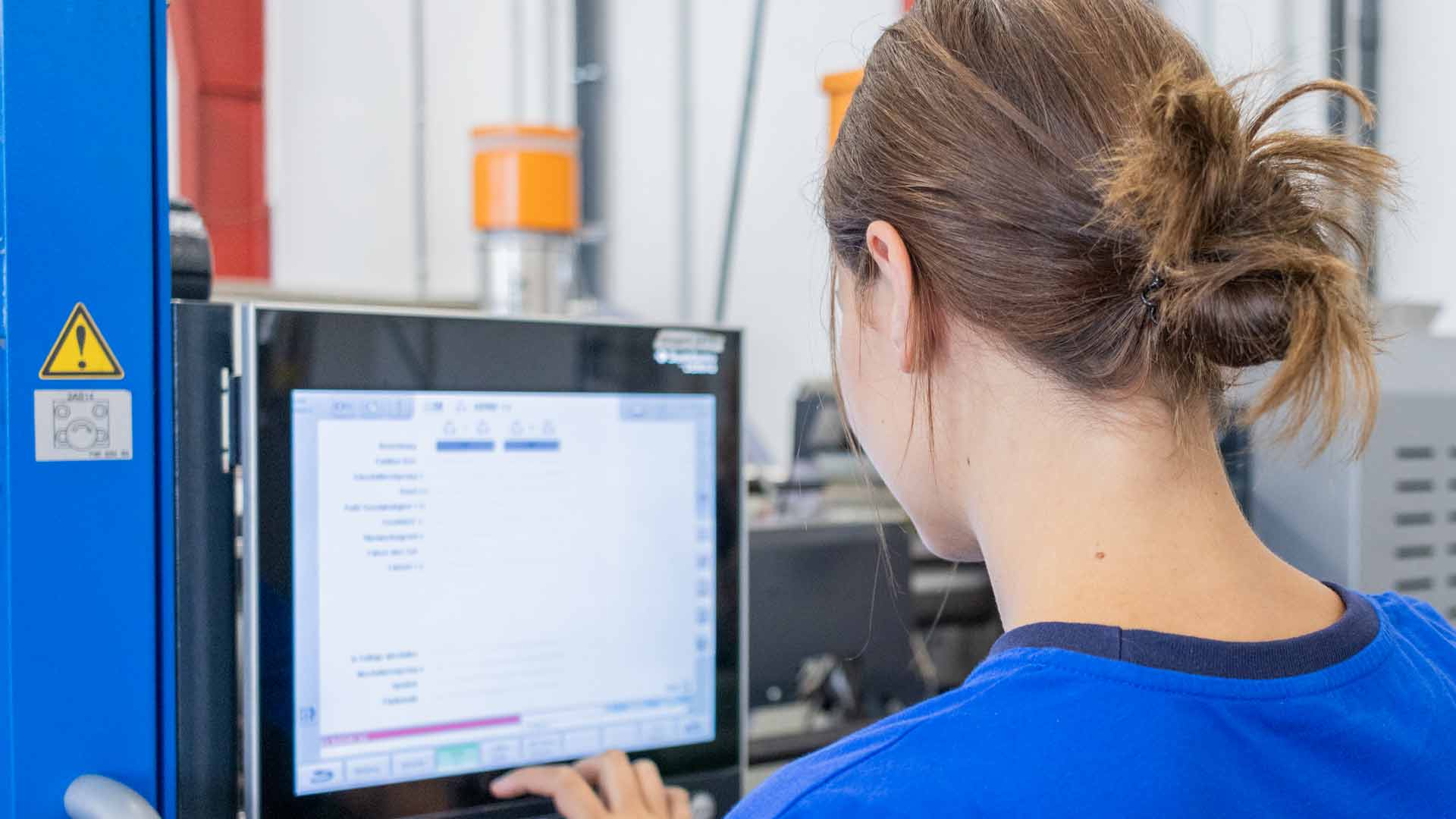 Mitarbeiterin an der Maschine bei ZURBRÜGG PLASTECH